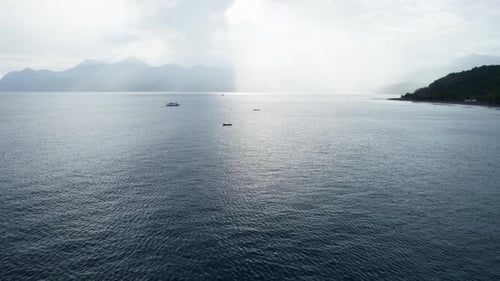 Wide Aerial View of Vast Ocean and Distant Tropical Mountain Coast