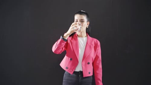Woman writing health on blackboard is drinking water.