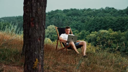 Männlicher kaukasischer Unternehmer arbeitet in der Natur. Der Mensch beendet die Arbeit am Laptop, schließt ihn und entspannt sich
.