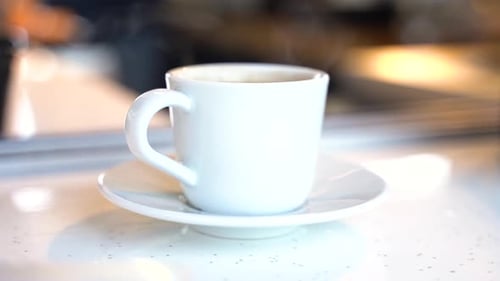 Hot Steaming Coffee on a Cafe Table in a White Cup