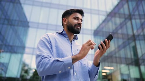 Man Talking on Phone Outside Modern Building