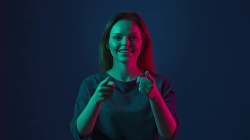 Selbstbewusste Frau zeigt mit dem Zeigefinger auf Sie und zeigt Daumen hoch Rothaarige Frau im Studio auf einem