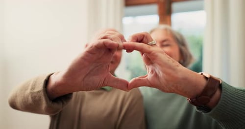 Senior Couple Makes Heart Shape with Hands