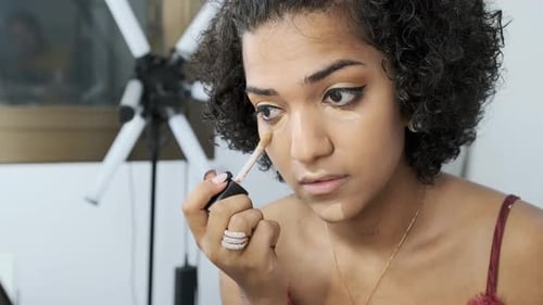 Young Woman Applies Concealer in Bright Studio