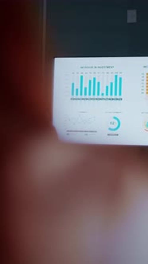 Confident Businesswoman Presenting Financial Growth Charts on Large Screen During Modern Office