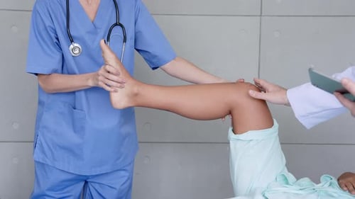 Medical Professional Examines Patient Leg in Hospital