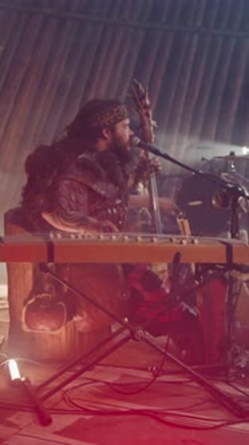 Un homme joue Igil et chante une chanson Old Fold sur scène avec Logs