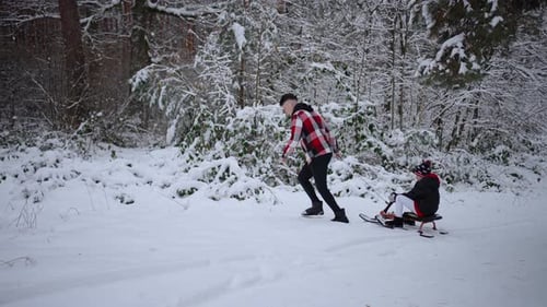 Father Takes Child on Sleigh Through Snowy Forest Concept of Sledding