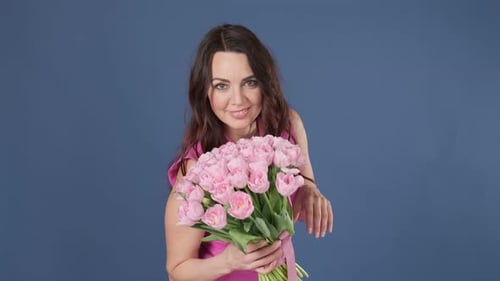 Woman Admiring Bouquet of Pink Tulips