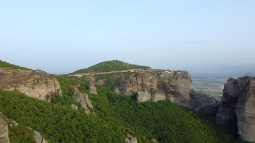Meteora rock formations and a monastery on top of high rocks.