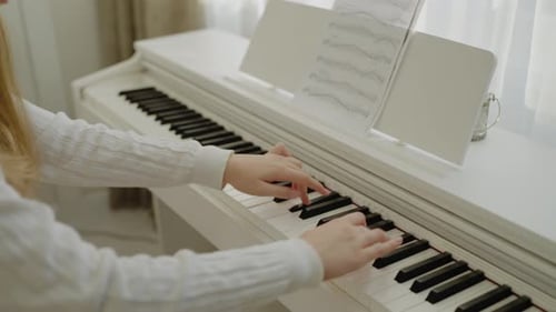 Young Woman Plays Piano With Sheet Music Indoors