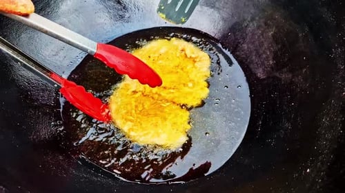 Golden Egg Frying in Black Pan with Sizzling and Bubbling Sounds