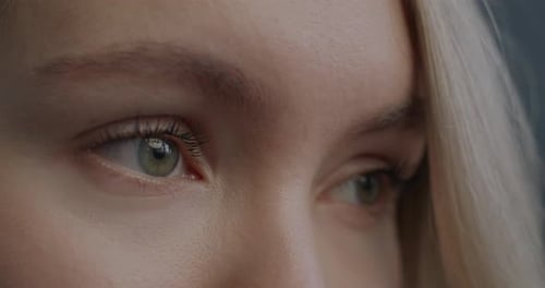 Closeup Slow Motion Portrait of Beautiful Female Eyes Looking Aside Blinking on Black Background