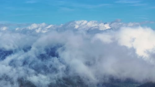 Aerial view of fluffy clouds over a serene landscape on a sunny day