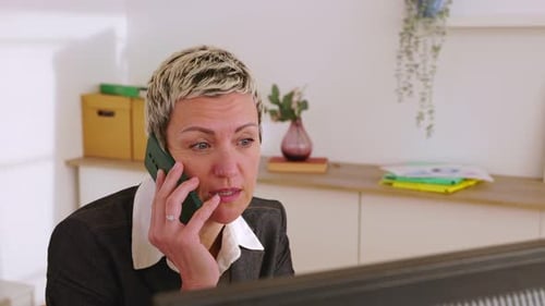 Middle Aged Businesswoman Talking on Phone in Office