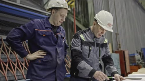 Workers at Factory Discuss Drawings Stock Clip Workers with Drawings on Factory Floor with Machines