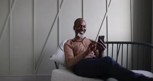 Man Relaxing with Phone on Couch Indoors