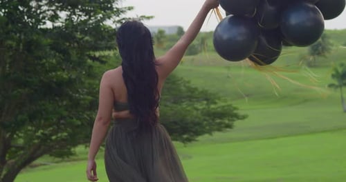 Woman with Balloons on a Tropical Hill