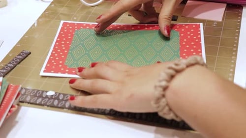 Creating handmade gift cards with Christmas theme pattern paper, woman hands close up