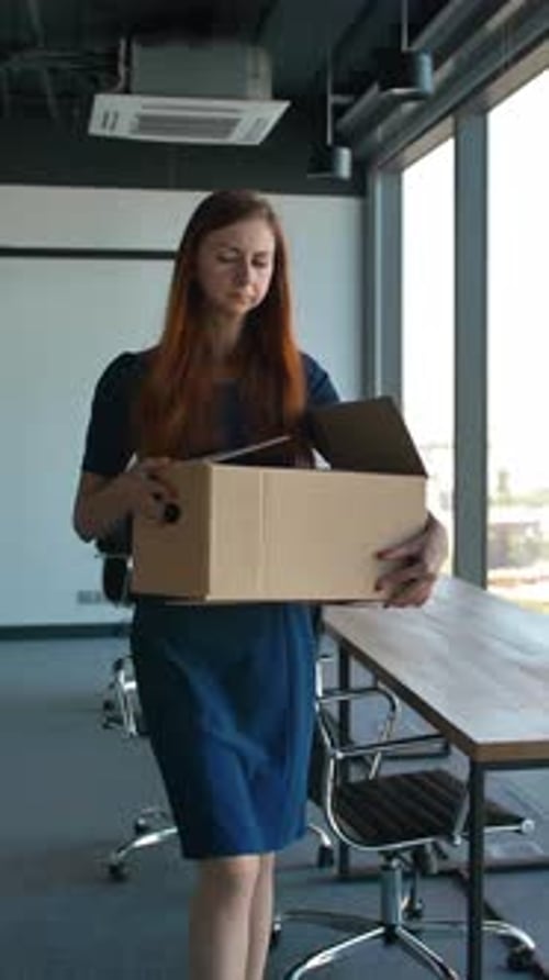 Vertical de uma funcionária triste saindo do escritório após ser demitida