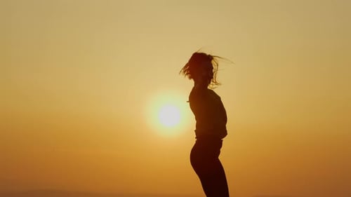 Woman Silhouette Arms Raised at Sunset