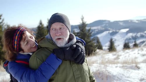 Smiling Senior Couple Embracing in the Snow