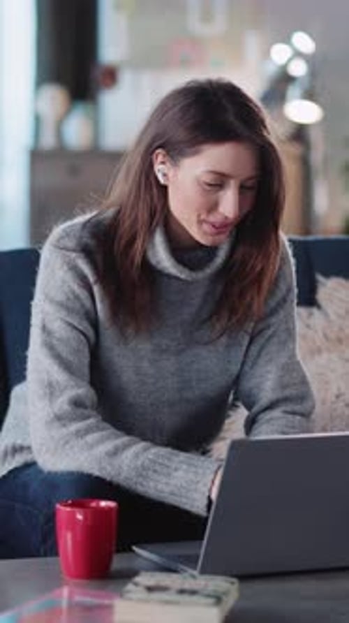 Smiling Woman Video Chats on Laptop at Home