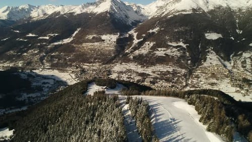 Picturesque high view over alpine ski trail in wintertime. Picturesque canopies of alpine trees. Win