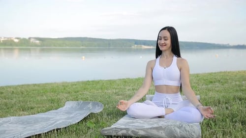 Young Girl Doing Yoga Near the Lake Meditation Pose Health Care Relax During Sports