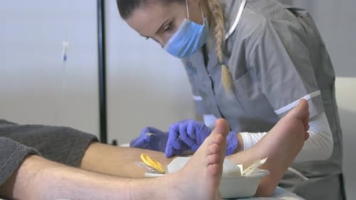 Female Nurse Preparing Male Patient For A Foot Surgery In The Hospital. tight shot