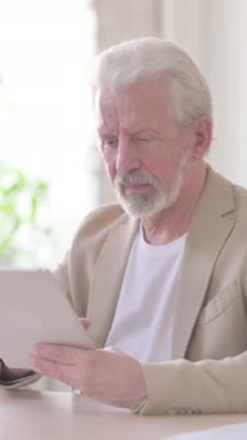 Old Man using Tablet while Sitting in Office, Vertical Video