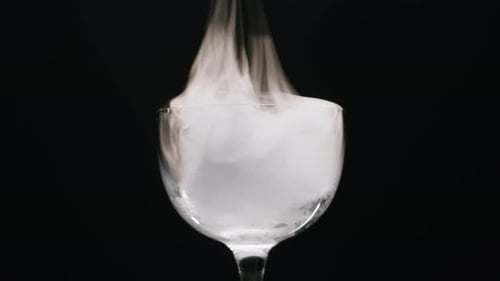 Vidro sobre fundo preto em fumaça, experimento químico, closeup, neblina, fumaça, vapor, textura