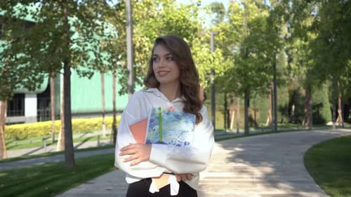 A Student with Textbooks Walks After College Lessons