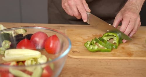 Hands Chopping Green Bell Pepper in Kitchen