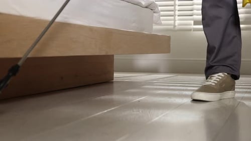 Exterminator Sprays Pesticide on the Floor in Bedroom