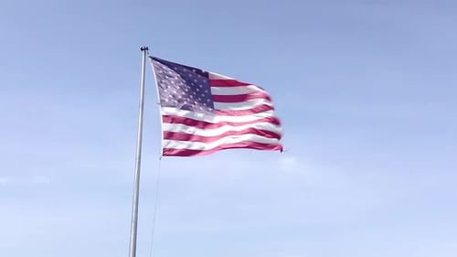 American Flag Waving Against Blue Sky