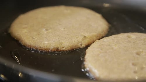 Pancakes Cooking in Hot Buttered Pan Close Up