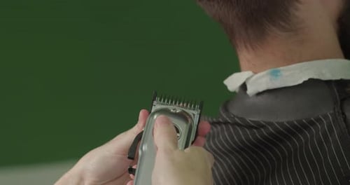 Barber Using Electric Clippers to Cut Client's Hair