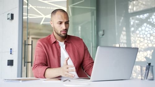 Worried businessman having problems with software or service on laptop computer while sitting