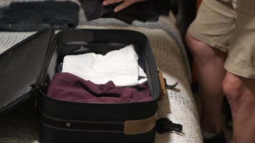 Man Packing Suitcase with Clothes for Travel