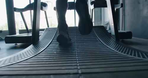 Closeup of Male Feet in Sneakers Training and Walking on Incline Treadmill