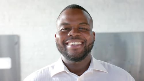 Portrait of happy african american casual businessman with beard smiling in office, slow motion