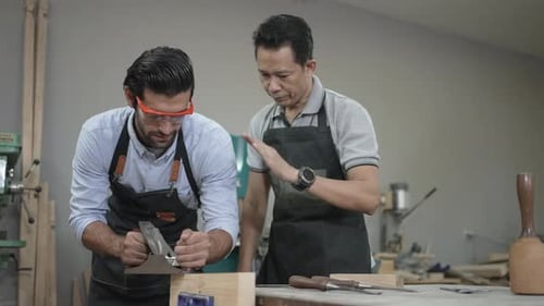 Carpenters are working together at workshop.