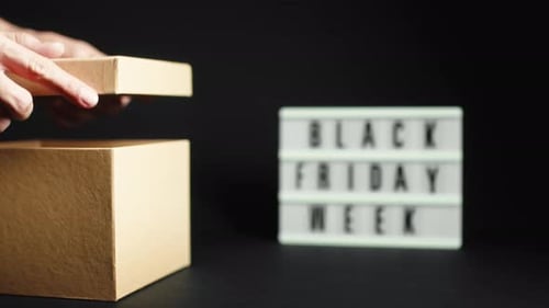 Hands Opening Cardboard Box During Black Friday Week
