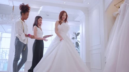 Beautiful bride discussing details with the wedding planner in studio.