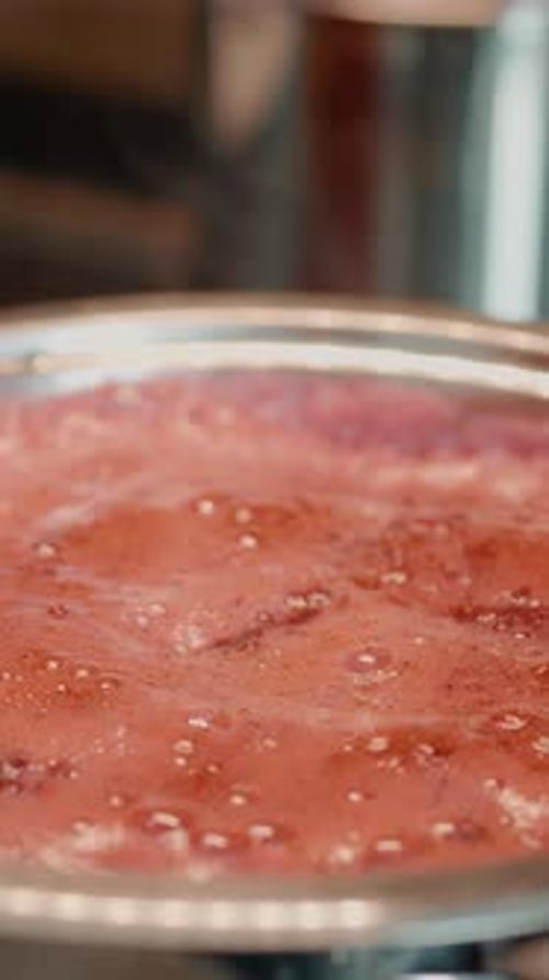 Stirring a Pinkish-Red Liquid in a Silver Pot