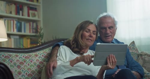 Senior Couple Relaxing With Tablet at Home