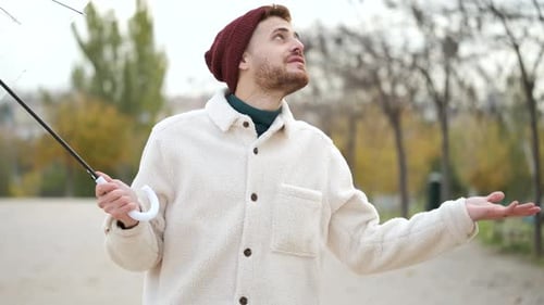 Man Enjoys Rainy Day Walk in the City Park