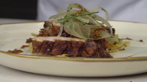 Chef adding finishing touches to dish in plating process, close up