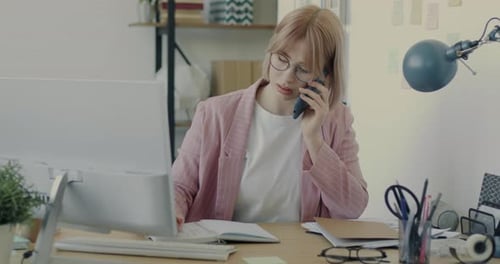 Portrait of Young Businesswoman Speaking on Mobile Phone Working in Office Alone